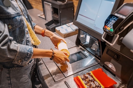Woman scanning items at self checkout